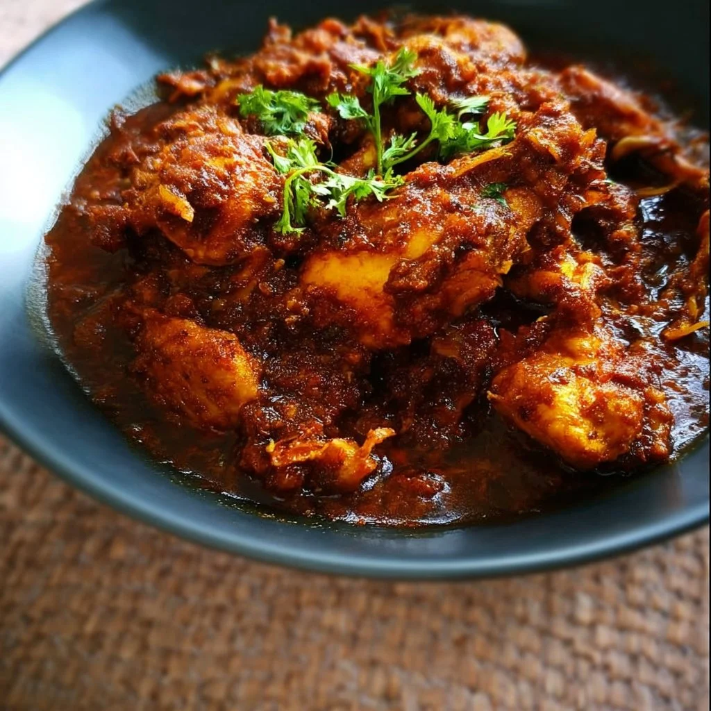 Plate of Easy Dry Chicken Masala garnished with fresh herbs.
